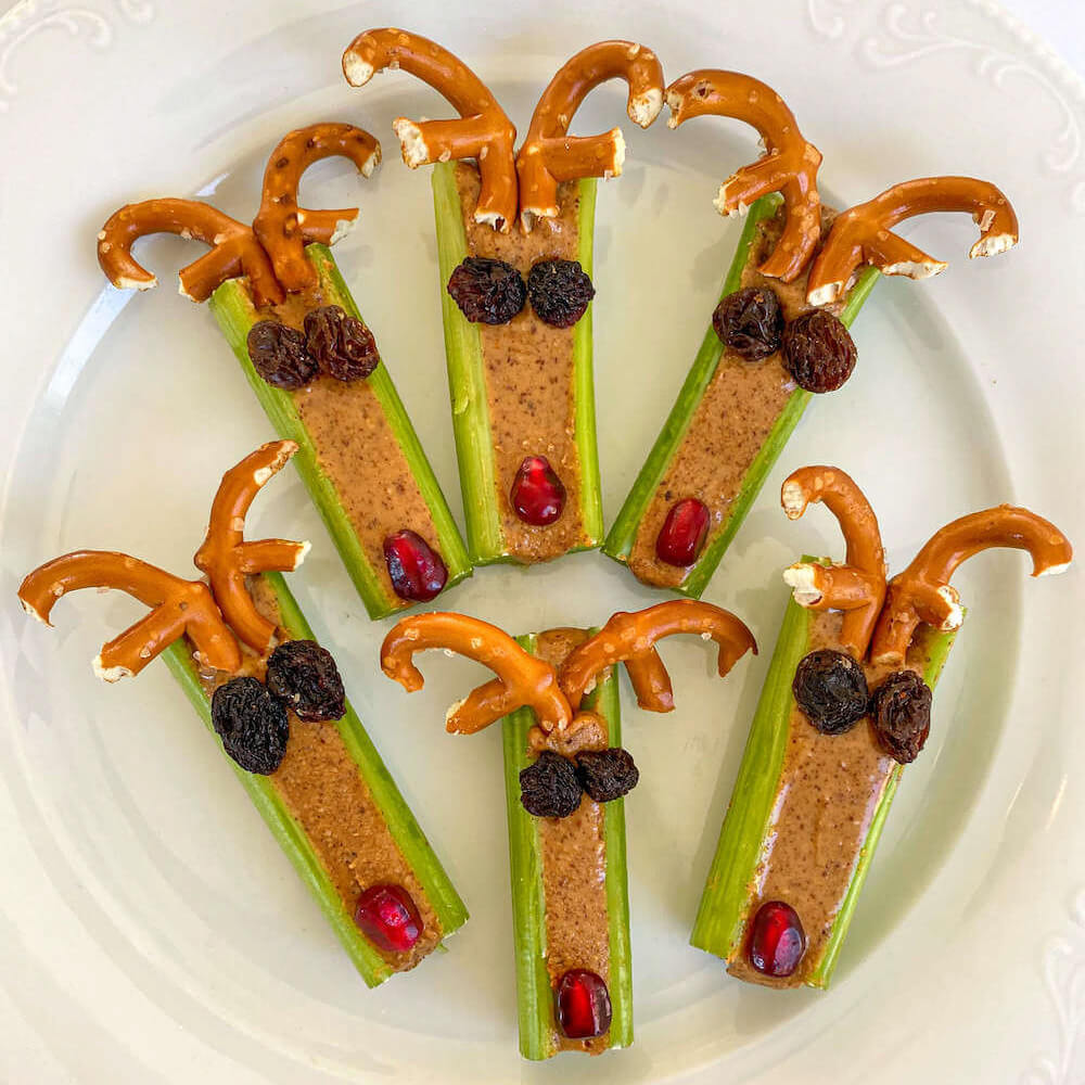 festive celery reindeer with peanut butter, raisins and pomegranate seeds