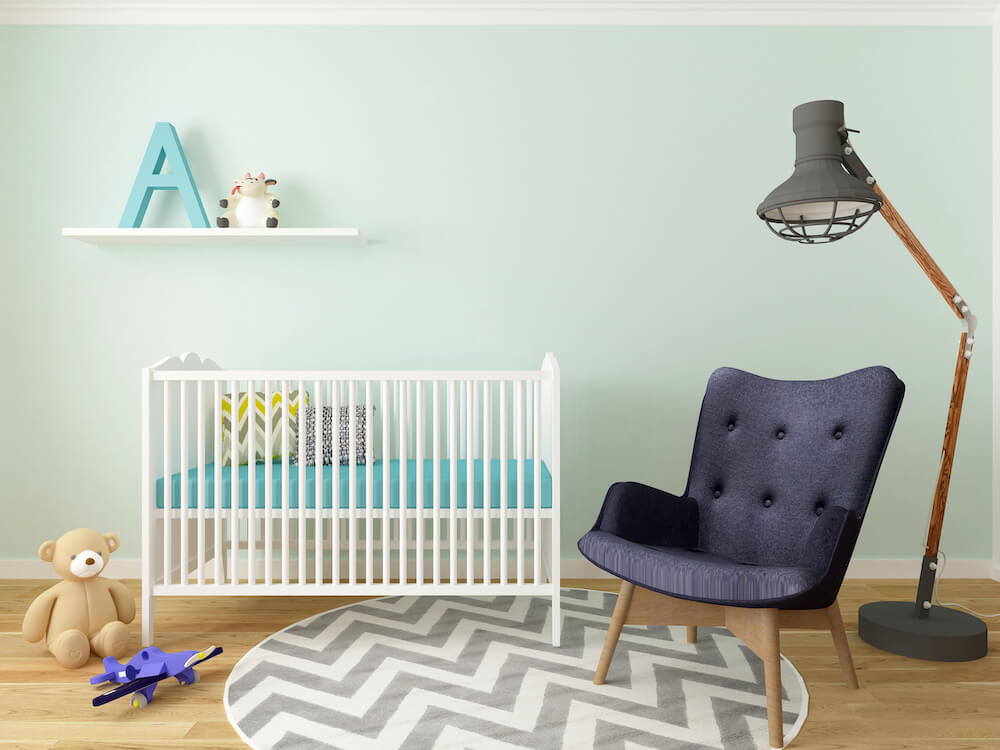 soft green kids room with crib and chair